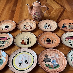 Pottery (PENNSBURY) Pitcher and 12 pottery plates depicting Amish life. Purchased in Lancaster PA in 1973. Ready to hang.Mint.