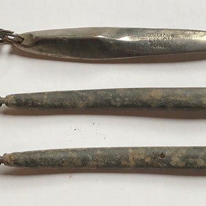 Jigging lures vintage 1950’s. 2 identical 5” lead lures and one Johnson’s Lujon nickel forged lure 4 1/2” in length. Free shipping to USA