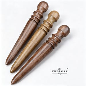 May include: Three wooden leather burnishing tools with tapered points and rounded handles featuring ribbed grips. The wood grain is visible in shades of dark brown and light tan. The text "The FIRSTNINA Design" is printed in the bottom right corner.