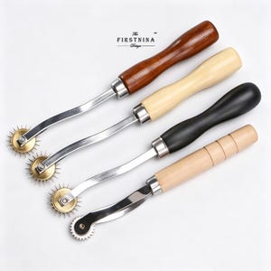 May include: Four sewing tracing wheels with wooden handles in dark brown, light beige, black, and natural wood. Each tool features a metal shaft and a serrated wheel at the tip. The text "The FIRSTNINA Design" is printed above the tools.