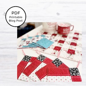 May include: Set of four red and white quilted pot holders with black and white snowflake print. The pot holders have a loop for hanging. The pot holders are on a white surface with a red and white checkered fabric.