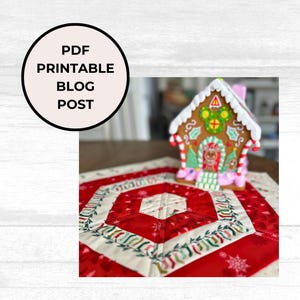 May include: A red and white quilted table runner with a green and white border. The runner is decorated with snowflakes and a gingerbread house is sitting on top of it.
