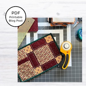 May include: A green, red, and gold patchwork quilt runner with a rotary cutter and cutting mat. The quilt runner is made of fabric squares with different patterns, including candy canes, flowers, and polka dots.  PDF Printable Blog Post.