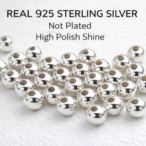 May include: Close-up of multiple shiny, round, silver beads. The beads have a high polish and are not plated. The text at the top reads "REAL 925 STERLING SILVER".
