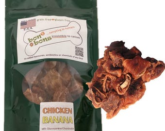 May include: A green bag of dog treats with a clear window, and a pile of treats next to it. The bag has text that reads "bone & bons" and "Chicken Banana". The treats are grain-free and gluten-free.