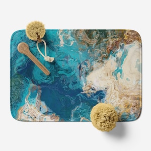 May include: A blue and beige abstract bath mat with a marbled design. The mat is made of a soft, absorbent material and is perfect for adding a touch of style to your bathroom.
