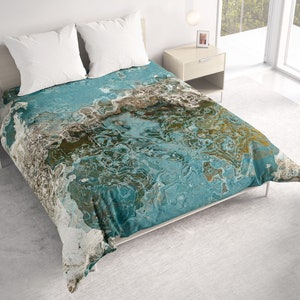 May include: A teal, brown, and white abstract patterned duvet cover with a white bed frame and two white pillows.