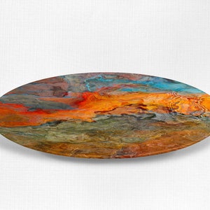 Puede incluir: Pintura abstracta sobre un posavasos redondo de madera. La pintura presenta colores que se arremolinan en naranja, rojo, azul y verde.