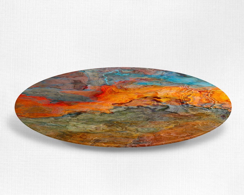 Puede incluir: Pintura abstracta sobre un posavasos redondo de madera. La pintura presenta colores que se arremolinan en naranja, rojo, azul y verde.