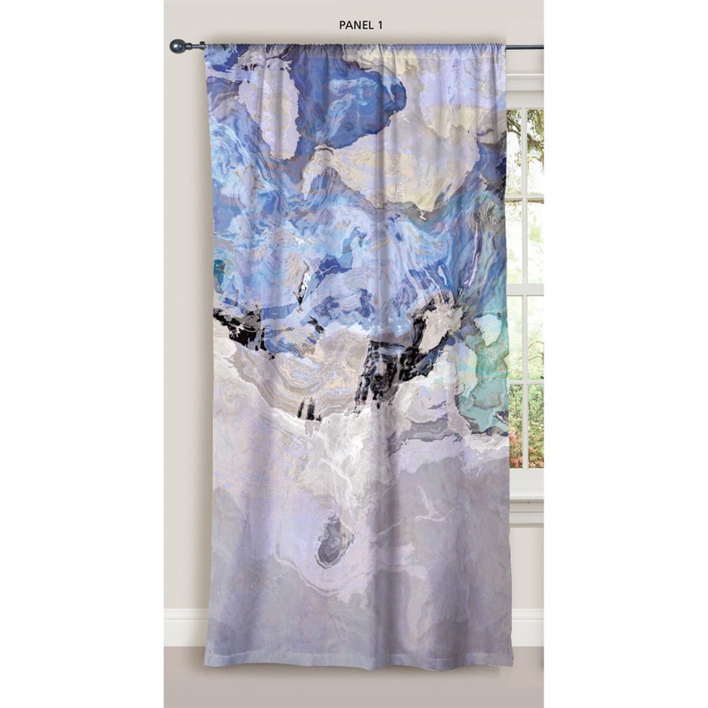 Pu&ograve; includere: Un pannello di tenda astratto blu e bianco con un design marmoreo. Il pannello &egrave; appeso a una finestra con una cornice bianca.
