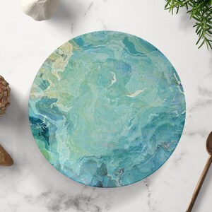 Op de afbeelding: Een ronde serveerschaal met een marmerpatroon in blauw, groen en wit. De schaal is perfect om hapjes, desserts of kaas op te serveren.