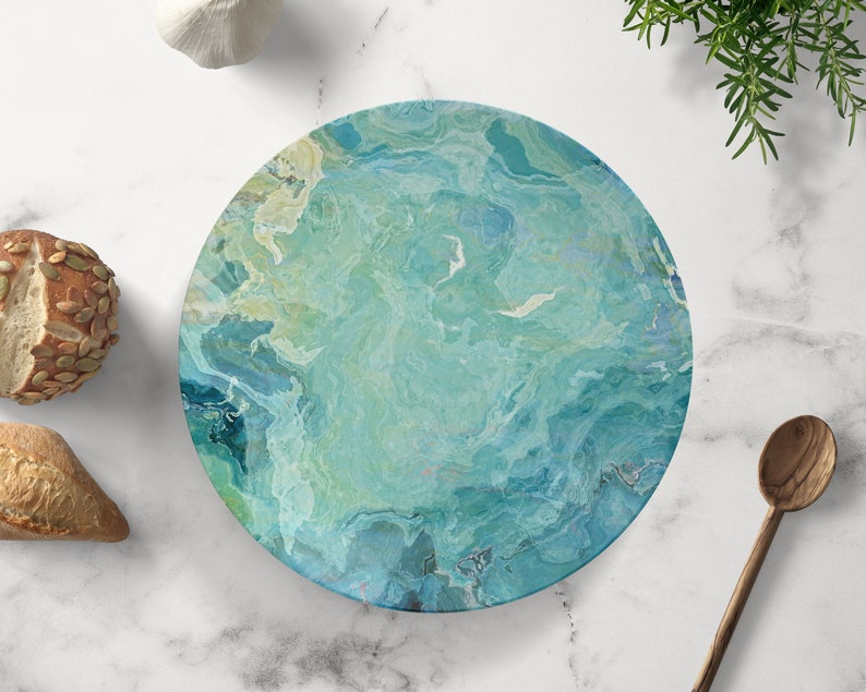 Op de afbeelding: Een ronde serveerschaal met een marmerpatroon in blauw, groen en wit. De schaal is perfect om hapjes, desserts of kaas op te serveren.