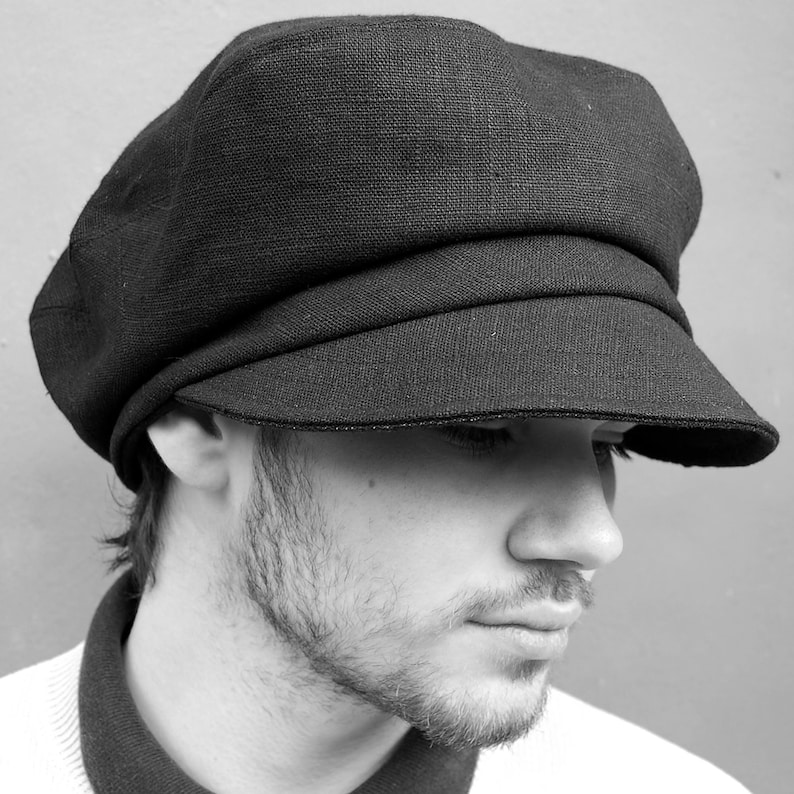 May include: A black newsboy cap with a structured design and a small peak. The cap is made of a textured fabric and features a rounded crown. The hat is a classic style, suitable for various outfits.