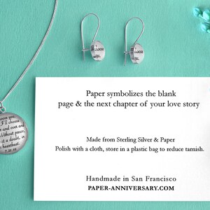 May include: A silver necklace and earrings set with a round pendant and earrings that say "I choose you. And I'll choose you over and over and over. Without pause. Without a doubt, in a heartbeat. 7.21.19" and "I choose you". The jewelry is on a light blue background with a card that says "Paper symbolizes the blank page & the next chapter of your love story. Made from Sterling Silver & Paper. Polish with a cloth, store in a plastic bag to reduce tarnish. Handmade in San Francisco. PAPER-ANNIVERSARY.COM".