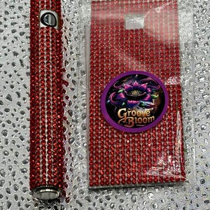 May include: Red rhinestone skin for a vape pen with a Groove Bloom logo. The skin is in a clear plastic bag. SKIN ONLY.