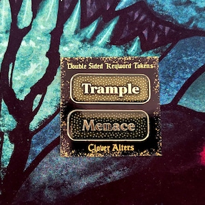 May include: A black card with two rectangular tokens that read "Trample" and "Menace" in gold lettering. The tokens are labeled "Double Sided Keyword Tokens" and "Clover Alters". The background is a dark blue and teal pattern.