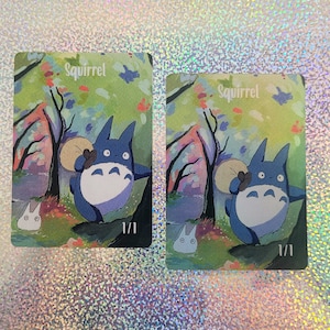 May include: Two watercolor paintings of a blue and white character carrying a brown bag with the word "Squirrel" at the top and "1/1" at the bottom.