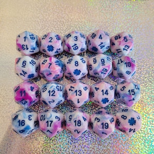 May include: Twenty pink and blue marbled dice with black numbers and a shamrock symbol on some of the dice.