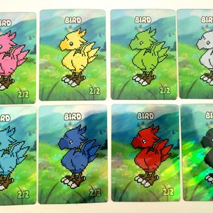 May include: Eight trading cards featuring pixelated birds in various colors: pink, yellow, green, gray, light blue, dark blue, red, and black. Each card has the word "BIRD" at the top and "2/2" at the bottom. The background shows a landscape.