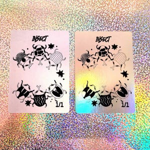 May include: Two white cards with black ink illustrations of insects. The cards have the word "INSECT" printed at the top and "1/1" printed at the bottom. The cards are on a glittery background.