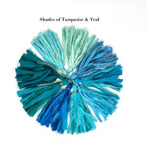 May include: A circular arrangement of fabric tassels in various shades of turquoise and teal, featuring frayed edges and tied tops. The text "Shades of Turquoise & Teal" is printed in black above the collection of colorful textile tassels.