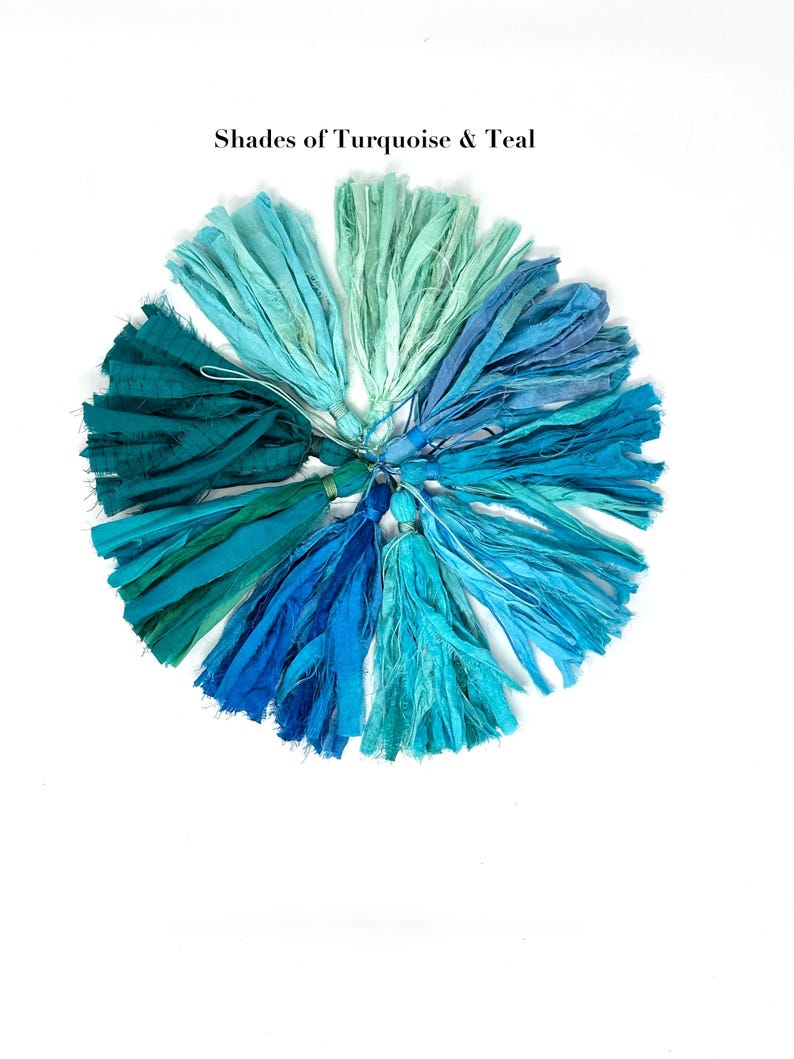 May include: A circular arrangement of fabric tassels in various shades of turquoise and teal, featuring frayed edges and tied tops. The text "Shades of Turquoise & Teal" is printed in black above the collection of colorful textile tassels.