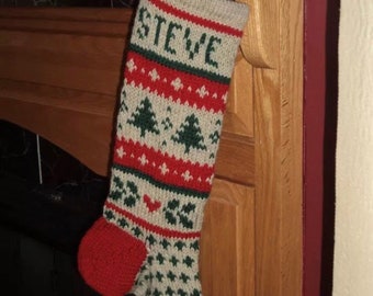 Könnte beinhalten: Ein gestrickter Weihnachtsstrumpf mit einem rot-weiß-grünen Muster. Der Strumpf trägt den Namen "STEVE" gestickt.
