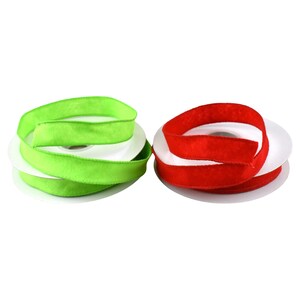 May include: Two spools of ribbon are displayed. One is a vibrant green, and the other is a bold red. The ribbon is a soft, velvety material, and each spool is neatly wound on a white cardboard core. These ribbons are suitable for crafts and gift wrapping.