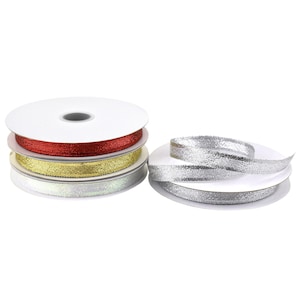 May include: Spools of decorative ribbon in red, gold, and silver glitter. The spools are stacked, with a separate spool of silver ribbon. Ideal for crafts, gift wrapping, and holiday decorations.