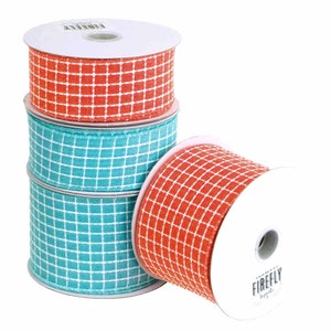 May include: Four spools of ribbon, two coral and two turquoise, with a white grid pattern. The spools are stacked on top of each other. The ribbon is made by Firefly Imports.