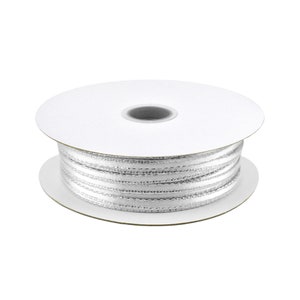 May include: A spool of white satin ribbon with silver thread accents.