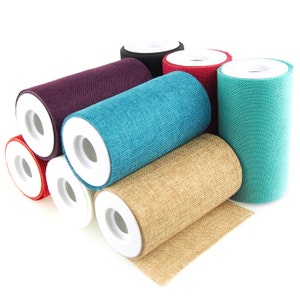 May include: A collection of fabric rolls in various colors, including teal, purple, red, and tan. Each roll has a white interior and a textured fabric exterior. The rolls are arranged in a slightly overlapping manner, showcasing the different colors and textures.