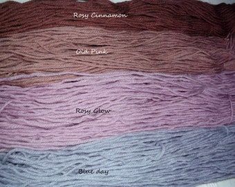 May include: Four horizontal skeins of yarn in distinct colors. The top is labeled Rosy Cinnamon in a deep brown, followed by Old Pink in a muted mauve, Rosy Glow in a soft lavender-pink, and Blue Day in a cool, dusty light blue shade.