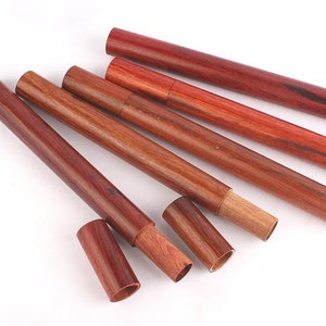 Peut inclure: Cinq porte-encens en bois de différentes tailles. Les porte-encens sont en bois rouge foncé avec un motif de grain de bois naturel.