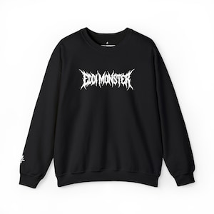 May include: Black crew neck sweatshirt with the white text "EDDI MONSTER" in a gothic font across the chest. The sweatshirt has long sleeves and a small white graphic on the left sleeve.