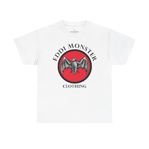May include: White t-shirt featuring a black and gray bat graphic inside a red circle, with the words "EDDI MONSTER" and "CLOTHING" in black text. The shirt has a crew neck and short sleeves.