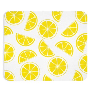 May include: White rectangular mousepad featuring a repeating pattern of bright yellow lemon slices and halves. The lemons are arranged in a random pattern across the surface, creating a fresh and summery design. The mousepad has rounded corners.