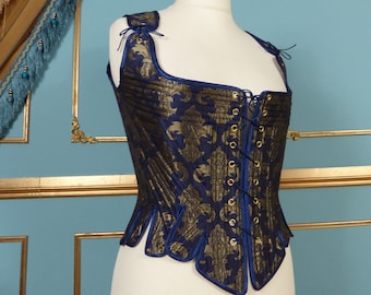 May include: A blue and gold brocade corset with a lace-up front and a scalloped hem.