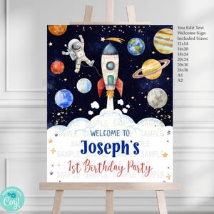 May include: A welcome sign for a 1st birthday party with a space theme. The sign features a rocket, an astronaut, planets, and stars on a dark blue background. The text reads "Welcome to Joseph's 1st Birthday Party".
