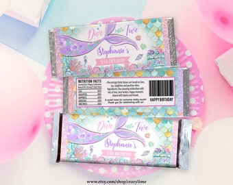 May include: Two chocolate bar wrappers with a mermaid theme. The wrappers say "Dive Into Five" and "Stephanie's 5th Birthday." The wrappers have a mermaid tail design, seashells, and a nutrition facts label.