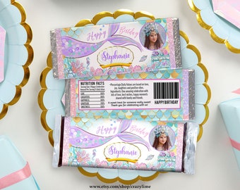 May include: Two chocolate bar wrappers with a mermaid theme. The wrappers feature a mermaid tail, the words "Happy Birthday" and "Stephanie", and a photo of a girl. The wrappers are decorated with sea creatures and a gold and teal scale pattern.