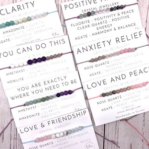 Puede incluir: Conjunto de diez pulseras coloridas con cuentas de cristal y mensajes inspiradores como "Claridad", "Puedes hacerlo", "Estás exactamente donde necesitas estar", "Amor y amistad", "Mentalidad positiva", "Alivio de la ansiedad", "Amor y paz", y "Amor y amistad".