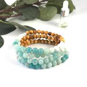 May include: A layered bracelet with green, blue, and white beads. The bracelet is made of natural stones and wood.