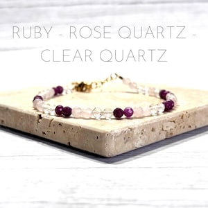 Puede incluir: Un delicado brazalete hecho con cuentas de rubí, cuarzo rosa y cuarzo transparente. El brazalete tiene un cierre dorado.