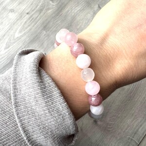 May include: A pink and white gemstone bracelet with round beads. The bracelet is made of natural stones and is a beautiful and unique piece of jewelry.