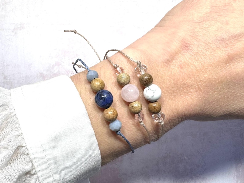 Puede incluir: Tres pulseras con cuentas de madera y detalles de piedras preciosas. Las pulseras est&aacute;n hechas con materiales naturales y presentan una piedra preciosa azul, rosa y blanca.