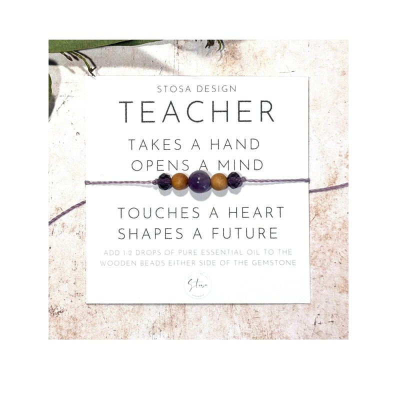 Puede incluir: Un brazalete morado y marr&oacute;n con el texto "Teacher Takes a Hand Opens a Mind Touches a Heart Shapes a Future" y "Add 1-2 drops of pure essential oil to the wooden beads either side of the gemstone".