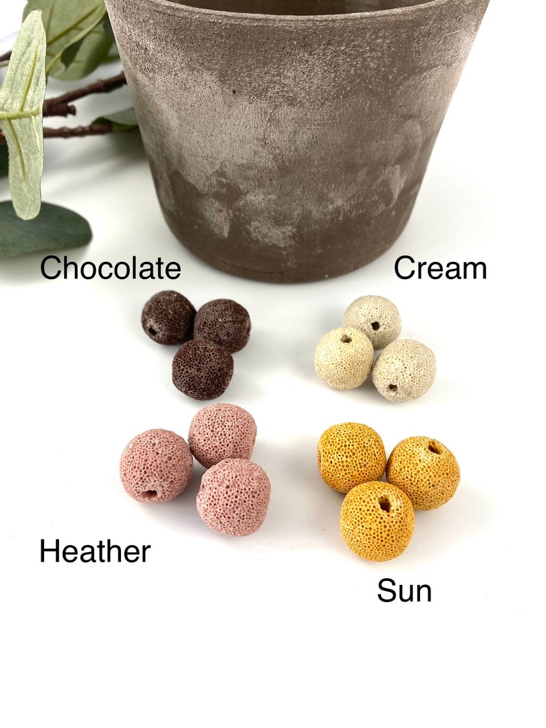 May include: Four sets of colorful lava rock beads in the colors chocolate, cream, heather, and sun. Each set contains three beads.