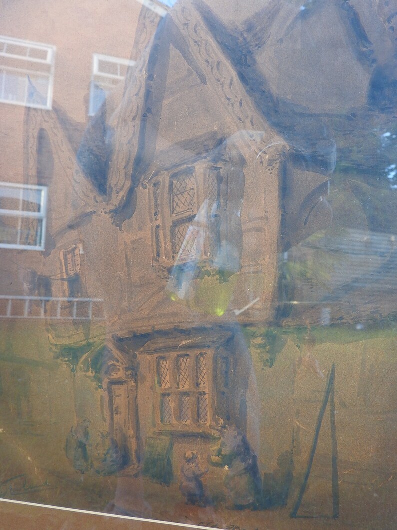 May include: A watercolor painting of a brown cottage with a thatched roof. The cottage has two windows and a door. The painting is framed and has a light brown background.