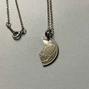 May include: Silver necklace with a broken heart pendant. The pendant has engraved text: "WATCH AND PRAY, BE ABSENT ONE ANOTHER". The necklace is displayed against a grey background.